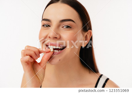 Smiling Person Taking a Health Supplement in a Bright Setting Smiling Person Taking a Health Supplement in a Bright Setting 123351069