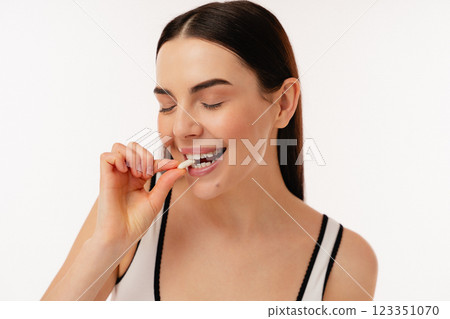 Young Woman Enjoying A Healthy Snack in a Bright Studio Setting Young Woman Enjoying A Healthy Snack in a Bright Studio Setting 123351070