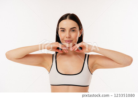 Confident Woman in Stylish Activewear Performing Wellness Pose on White Background Confident Woman in Stylish Activewear Performing Wellness Pose on White Background 123351080