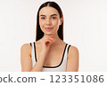 Smiling Woman Posing in Simple White Tank Top on White Background 123351086