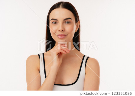Smiling Woman Posing in Simple White Tank Top on White Background Smiling Woman Posing in Simple White Tank Top on White Background 123351086