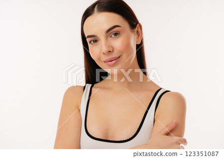 Confident Woman Smiling in Minimalist Studio Against a White Background Confident Woman Smiling in Minimalist Studio Against a White Background 123351087