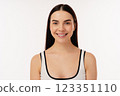 Smiling Individual With Natural Makeup Against a Minimalist White Background 123351110
