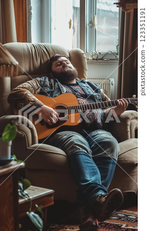 happy cheerful fat man playing on guitar, man with obesity at home playing hobby 123351191