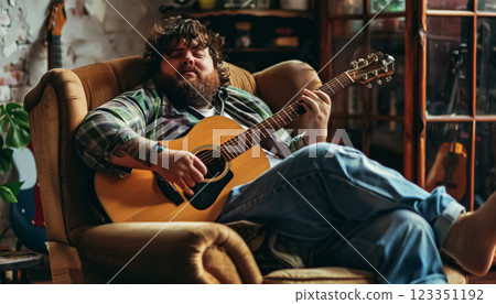 happy cheerful fat man playing on guitar, man with obesity at home playing hobby 123351192