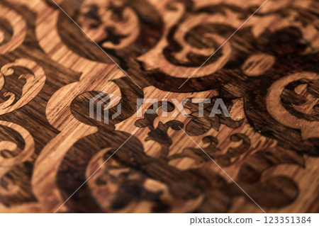 Engraved ornamental baroque design on wooden surface. Macro photo 123351384