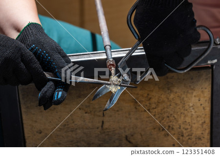 Molten glass and tools, works of a glass blowing workshop Molten glass and tools, works of a glass blowing workshop 123351408