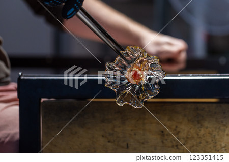 Sculpting flower of molten glass, works of a glass blowing Sculpting flower of molten glass, works of a glass blowing 123351415