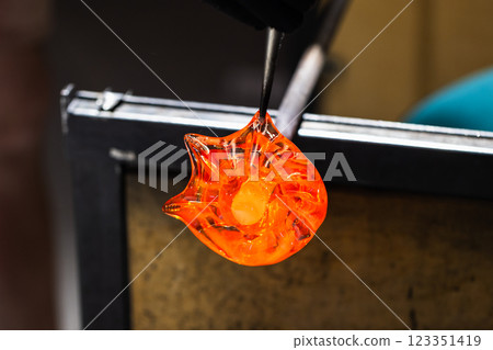 Sculpting molten glass into a flower shape, glass blowing Sculpting molten glass into a flower shape, glass blowing 123351419