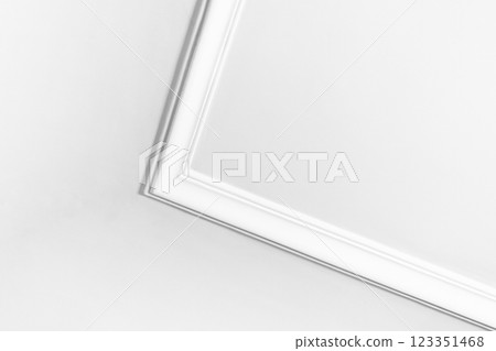 White ceiling corner featuring minimalist design with detailed molding 123351468