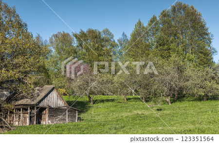 A serene countryside setting featuring a rustic wooden barn 123351564