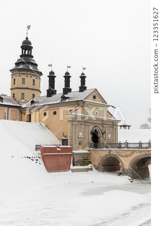 Vertical scenic view of a historic castle and bridge covered in snow. Nesvizh 123351627