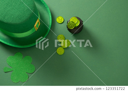 St Patricks day and March 17 concept with green Leprechaun Hat, clover leaf and green coins on green background. View from above. Copy space. 123351722
