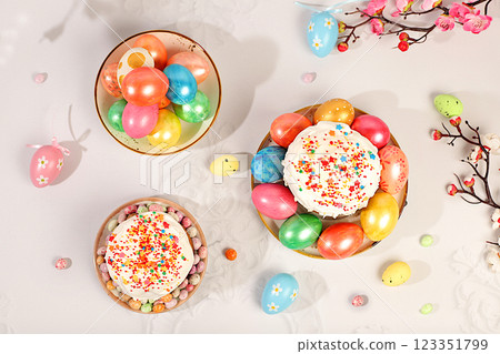 Happy Easter concept. Abstract Easter composition with traditional Russian kulich with meringue and decorated eggs on elegant kitchen table with spring sakura flowers. Screen banner with space for 123351799