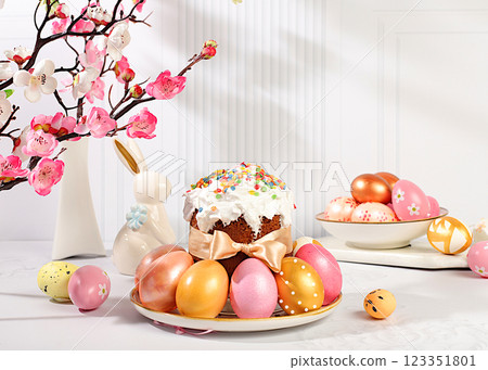 Happy Easter concept. Abstract Easter composition with traditional Russian kulich with meringue and decorated painted eggs on elegant kitchen table with spring sakura flowers. Banner for screen with 123351801