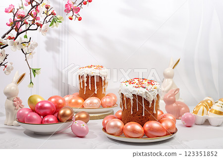 Abstract Easter composition with traditional Russian kulich with meringue and decorated eggs on elegant kitchen table with spring sakura flowers. Happy Easter concept. Screen banner Abstract Easter composition with traditional Russian kulich with meringue and decorated eggs on elegant kitchen table with spring sakura flowers. Happy Easter concept. Screen banner 123351852