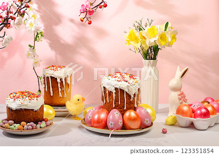 Happy Easter concept. Abstract Easter composition with traditional Russian kulich with meringue and decorated eggs on elegant kitchen table with spring sakura flowers. Screen banner with space for Happy Easter concept. Abstract Easter composition with traditional Russian kulich with meringue and decorated eggs on elegant kitchen table with spring sakura flowers. Screen banner with space for 123351854