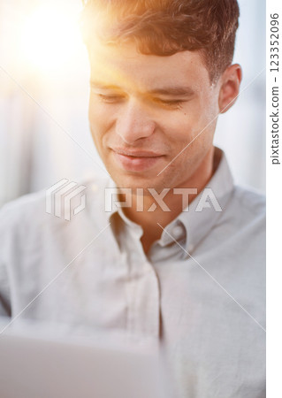 Shot of a young businessman using a laptop in a modern office 123352096