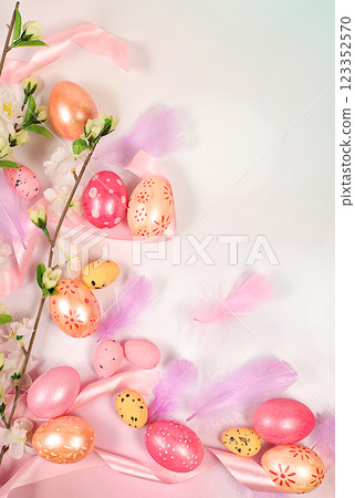 Abstract spring easter composition with pink painted eggs, feathers, butterflies, flowering branches and flowers. Happy easter concept. Screen banner with space for greeting text 123352570