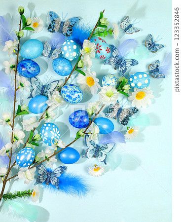 Abstract spring easter composition with blue painted eggs, feathers, butterflies, flowering branches and flowers. Happy easter concept. Screen banner Abstract spring easter composition with blue painted eggs, feathers, butterflies, flowering branches and flowers. Happy easter concept. Screen banner 123352846