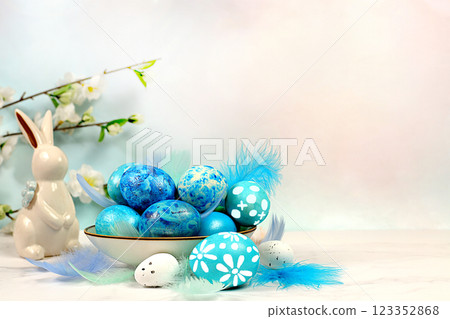 Happy Easter concept. Abstract Easter composition with blue decorated eggs, feathers, flowering branches and flowers. Banner for screen with space for greeting text Happy Easter concept. Abstract Easter composition with blue decorated eggs, feathers, flowering branches and flowers. Banner for screen with space for greeting text 123352868