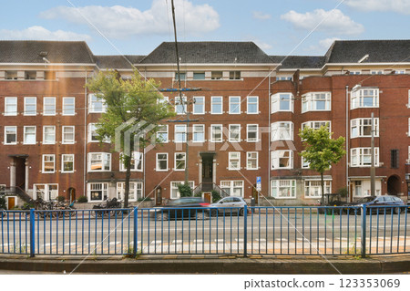 A striking view of a modern urban residential building featuring unique architectural elements and vibrant greenery. A perfect blend of nature and urban living. 123353069