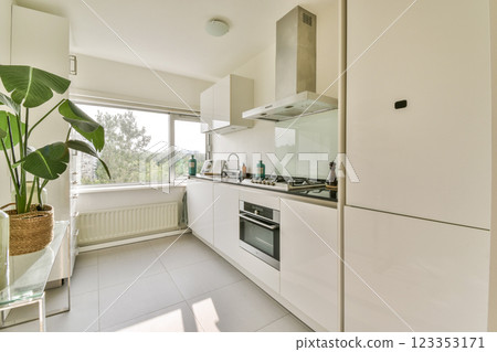 A sleek, modern kitchen featuring minimalist design elements, plants, and large windows allowing natural light, creating a fresh and inviting atmosphere. A sleek, modern kitchen featuring minimalist design elements, plants, and large windows allowing natural light, creating a fresh and inviting atmosphere. 123353171