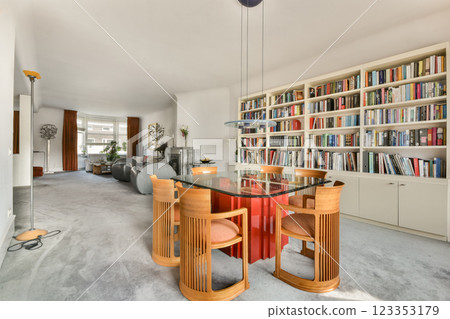 A contemporary living room featuring stylish furniture, a well-organized bookshelf, and a cozy atmosphere, ideal for relaxation and gatherings. 123353179
