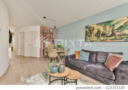 A stylish modern living room featuring a cozy sofa, vibrant artwork, and elegant furniture, creating a welcoming ambiance for relaxation and entertainment. A stylish modern living room featuring a cozy sofa, vibrant artwork, and elegant furniture, creating a welcoming ambiance for relaxation and entertainment. 123353185
