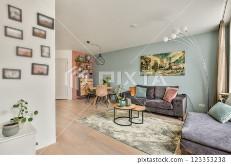 A contemporary living room showcasing elegant furniture and decor elements, featuring a cozy atmosphere with artwork and plants enhancing the ambiance. 123353238