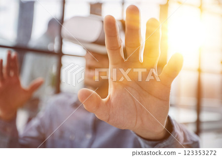Cool handsome man put on virtual reality goggles for the first time in the office. 123353272