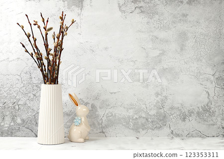 Composition with a rabbit and willow branches in a vase. Happy Easter concept, banner or advertisement for screen or store, template for design, spring card, selective focus 123353311