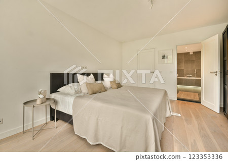 A stylish modern bedroom featuring a neutral color palette, minimal furnishings, and elegant decor. Soft lighting enhances the serene atmosphere. 123353336