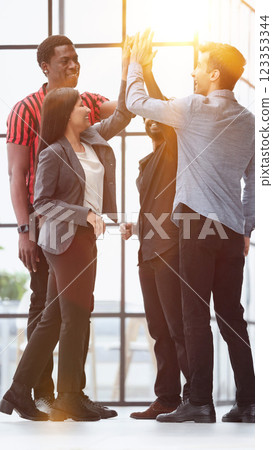 successful business team giving each other a high-five, standing successful business team giving each other a high-five, standing 123353344