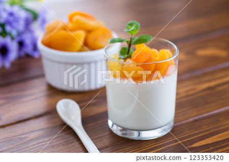 Light fruit yogurt with dried apricots on dark wooden table 123353420