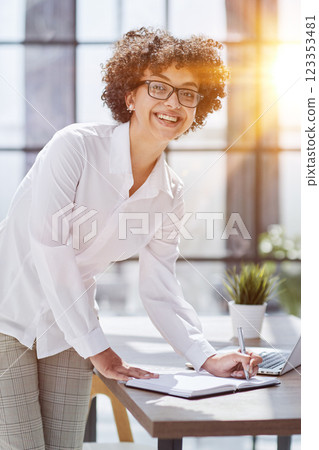 business woman writing at her desk in a modern office business woman writing at her desk in a modern office 123353481