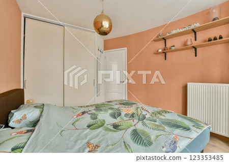 A tranquil bedroom featuring earthy wall colors, decorative shelving, and a nature-inspired bedspread, creating a warm and inviting atmosphere. A tranquil bedroom featuring earthy wall colors, decorative shelving, and a nature-inspired bedspread, creating a warm and inviting atmosphere. 123353485