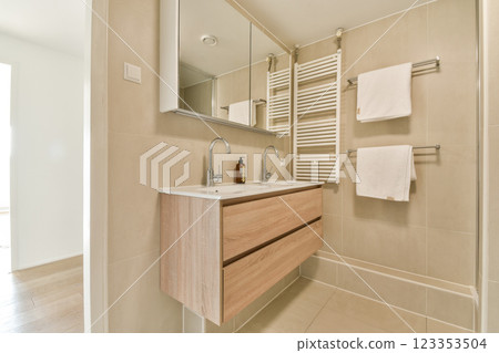 A contemporary bathroom featuring elegant wood accents, a minimalist design, and a clean aesthetic that emphasizes functionality and relaxation. 123353504