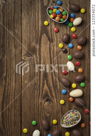 Easter chocolate eggs and colorful dragees Easter chocolate eggs and colorful dragees 123354072