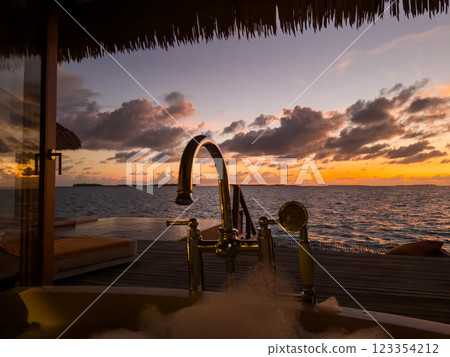 Sunset views from overwater pool villa in Maldives Sunset views from overwater pool villa in Maldives 123354212