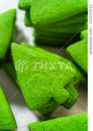 A stack of plain green Christmas tree cookies, emphasizing their vibrant green color and smooth texture. 123355012
