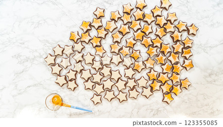 An artistic top-down arrangement of gingerbread star cookies decorated with royal icing, with gold luster dust adding a glamorous finish to these festive treats. 123355085