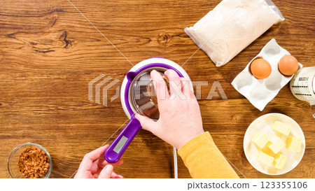 Flat lay. Carefully greasing a bundt cake pan in preparation for baking a delicious gingerbread bundt cake with caramel frosting. 123355106