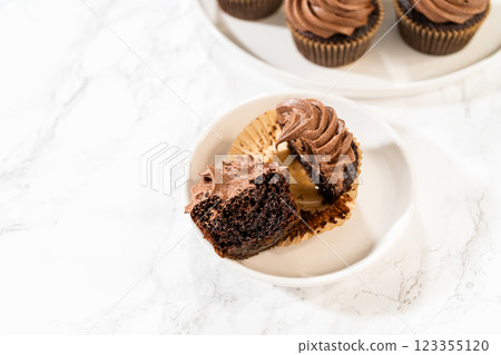A delectable chocolate cupcake, sliced in half, elegantly presented on a plate. A delectable chocolate cupcake, sliced in half, elegantly presented on a plate. 123355120