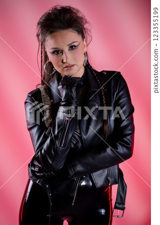 An Edgy Fashion Portrait Featuring a Leather Jacket Set Against a Vibrant Pink Background 123355199