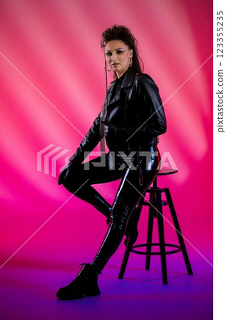 A Bold and Edgy Fashion Model Poses in a Stunning Leather Outfit with a Colorful Background 123355235