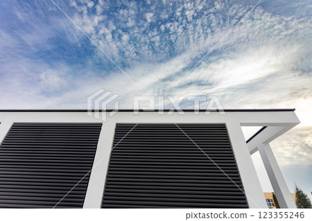 Modern Architectural Detail Highlighted Against a Dramatic and Cloudy Sky Backdrop 123355246