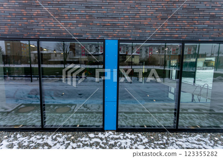 A modern glass facade with a striking blue accent in an urban setting captivates eyes 123355282
