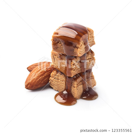 Caramel candy with caramel topping and almonds nuts on white backgrounds 123355561