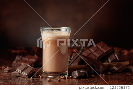 Hot chocolate cocoa drink in glass mug and pieces of  bitter chocolate. 123356375